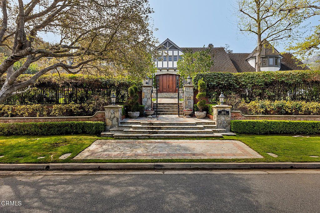 Front facade of 860 Flintridge Avenue with mature landscaping and arched portico entry.
